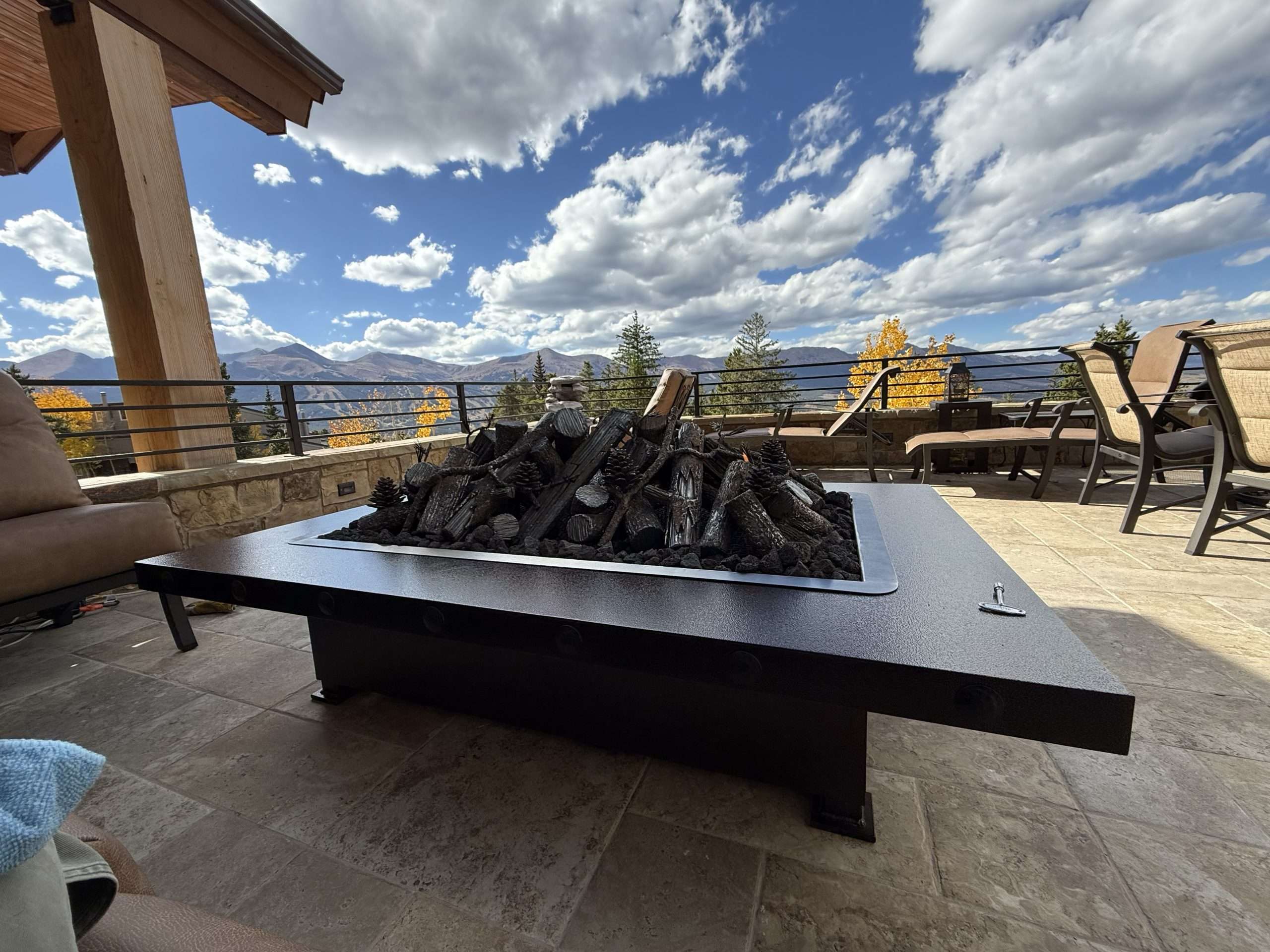 Handcrafted steel log gas fire feature on a mountain patio